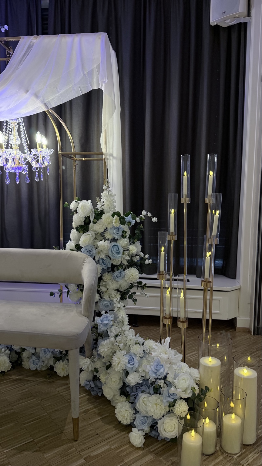 Bougies, fleurs blanc et bleu et chandeliers dorés